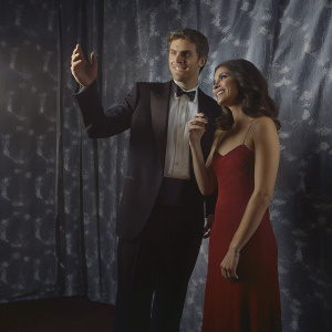 Liam Hemsworth and Nina Dobrev at an exclusive Hollywood gala. Dark red carpet backdrop, close-up candid photo.