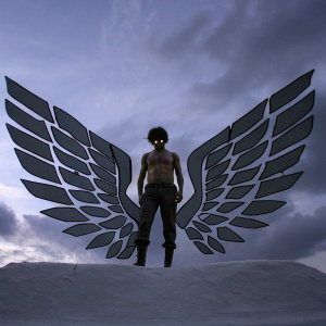 Eren Yeager, shirtless, muscular build, fierce look. Standing on a white backdrop. Large wing-like emblem on his back. Digital art illustration