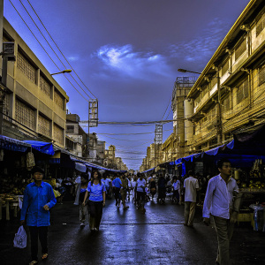 Nana Plaza, bustling commercial district in Bangkok. Colorful stalls, shops, and street food vendors. Lively atmosphere with ornate signage and urban architecture. Crowds of locals and tourists enjoying the vibrant urban scene.