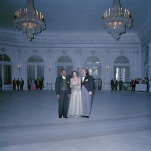 Darren Walker, Susan Cohn Rockefeller, David Rockefeller Jr. posing at the annual gala. Lavish ballroom setting, chandeliers overhead