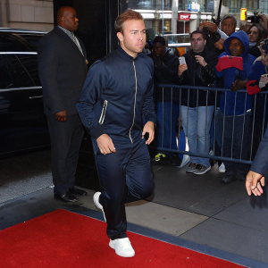 Mario Götze in training gear, on a bustling city street. Running past excited fans.