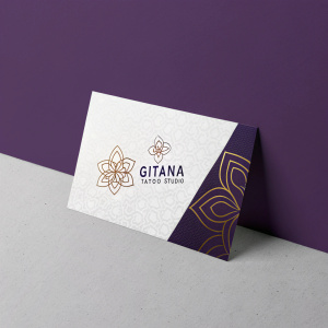 Promotional card for Gitana Tattoo Studio. White cardstock with modern graphic design. Deep purple background, featuring studio name and details in contrasting colors.