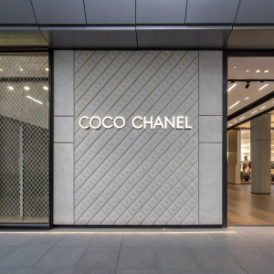 Inspiring quote from Coco Chanel on a sleek, modern gray background. The grid pattern adds a subtle texture.