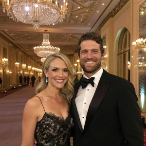 Samantha Atlas and Andrew Bowen smiling at the prestigious Hollywood gala. Luxurious ballroom setting with chandeliers