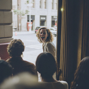 Kiernan Shipka in a candid photo shoot. Cheerful demeanor, standing against a bustling city street backdrop.