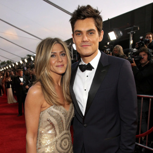 Jennifer Aniston and John Mayer at the annual Grammy Awards. They are posing together on the red carpet, surrounded by flashing cameras and eager fans.