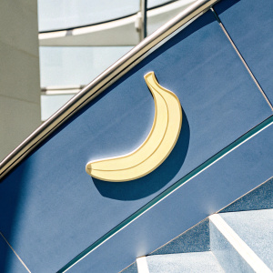 Cartoony banana logo with sleek design. Modern purple backdrop.