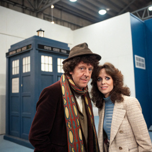 A casual studio snapshot featuring Tom Baker and Mary Tamm. Behind the scenes at Doctor Who set, the TARDIS prop is visible. Even lighting, modern wallpaper
