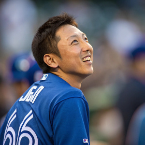 Munenori Kawasaki, baseball player, in a candid shot. Blue jersey with number 66. Focused on his face, background blurred.