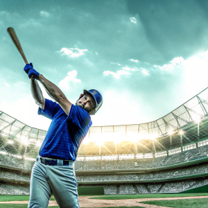 Norichika Aoki, in his bright blue Mets jersey, striking a powerful batting pose. The vibrant stadium lights, filled with enthusiastic fans, create an electrifying atmosphere behind him.