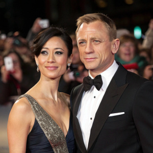 Daniel Craig and Satsuki Mitchell at the premiere event. Formal attire, blurred background with paparazzi and fans