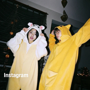 Instagram post featuring K-pop idols in Halloween costumes. Festive decorations and Spanish language hashtags.