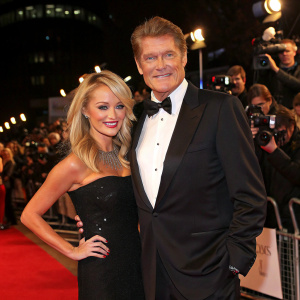 David Hasselhoff and Hayley Roberts at a high-profile movie event. Dressed in formal attire, they pose confidently in front of flashing cameras and a star-studded audience.