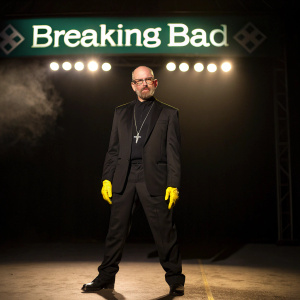 Walter White in his iconic Heisenberg outfit. Black suit and yellow accessories under the spotlight. Breaking Bad logo in the background.