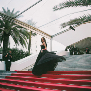 Zendaya at Cannes Film Festival premiere. Elegant black dress, striking pose on glamorous red carpet.