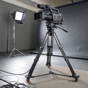 A high-end Ikegami HC-HD300 camera system set up on a robust tripod in a studio environment.