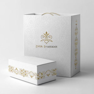 Sophisticated packaging design for the Zara Shahjahan brand. White box with embossed gold text 'ZARA SHAHJAHAN'. Elegant and minimalist style.