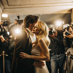 Kevin Zegers and Marisa Coughlan at a glamorous Hollywood party. Kevin leans in to give Marisa a friendly cheek kiss amidst a sea of paparazzi.