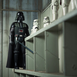 A highly detailed action figure of Darth Vader from Star Wars, standing in a dramatic pose on a collector's shelf.