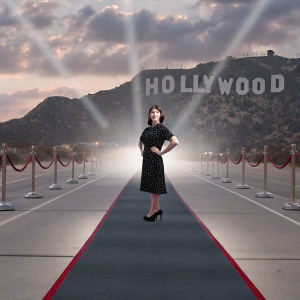 Sarah Silverman, in a black polka-dotted dress, at the star-studded awards ceremony. Red carpet, Hollywood sign in background