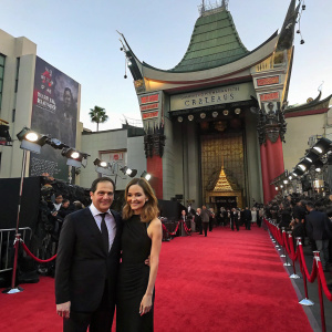 Michael Stuhlbarg and Mai-Linh Lofgren at the TCL Chinese Theatre for a movie premiere. Lavish red carpet, flashing cameras.