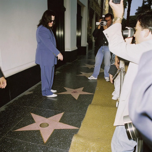 Ozzy Osbourne's star on the Hollywood Walk of Fame. Surrounded by fans and paparazzi on a sunny day.
