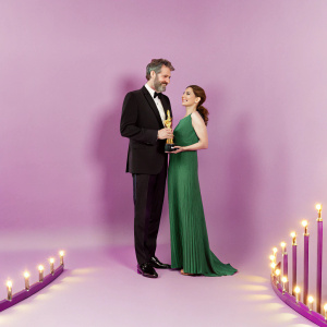 David Benioff and Amanda Peet at the Academy Awards ceremony. David is dressed in a black tuxedo, while Amanda sports a long, flowing, emerald green dress.