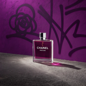 Promotional image for Chanel Perfume. Graffiti style hashtag and purple background. Modern and edgy design.