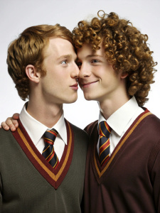 two cute smiling slender muscled curly high school guys in Hogwarts uniform kissing