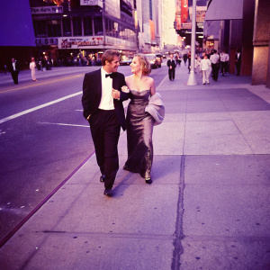 Josh Lucas and Christina Applegate, dressed in formal attire, walking on the busy streets of New York City during a film festival.