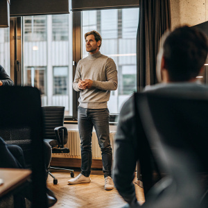 Xabi Alonso, focused expression, in casual attire. Office conference setting with modern furniture and large windows
