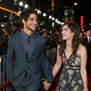 Tyler Posey and Seana Gorlick at a bustling Hollywood premiere. Holding hands, smiling amidst a crowd of fans and photographers.