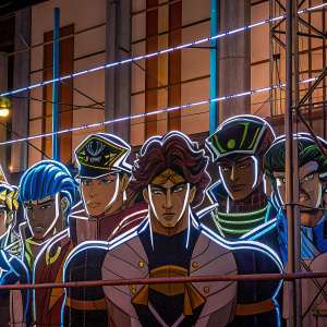 A vibrant group photo of characters from JoJo's Bizarre Adventure. Each character with unique hairstyles, outfits, and headgear. The scene is a dynamic, colorful illustration with intricate lines and bold hues.