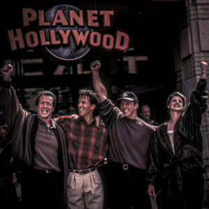 Arnold Schwarzenegger, Bruce Willis, Demi Moore, and Sylvester Stallone celebrating the opening of Planet Hollywood. Cheerful and lively event, casual attire, logo backdrop