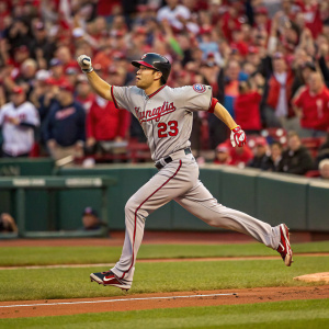 Tommy Milone, in full motion on a baseball field. His gray jersey with red accents stands out. Crowd in the background