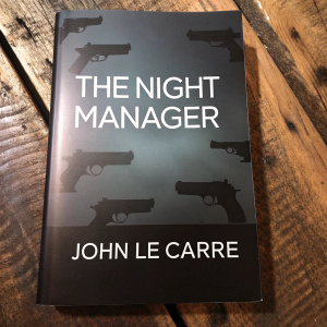 Book cover for 'The Night Manager' by John le Carré. Dark and foreboding atmosphere. Silhouettes of guns scattered across the cover. Title and synopsis in white text.