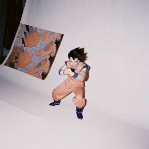 Vegeta, from Dragon Ball Z, in a fierce battle stance. His muscles flexed and face resolute. Orange and blue outfit, dynamic background of swirling energy and stars