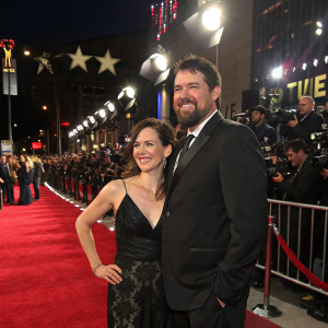 Marcus Luttrell and Melanie Juneau at a glamorous movie premiere. Red carpet, flashing cameras, star-studded crowd