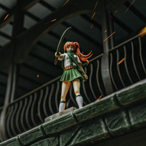 Anime depiction of Kagome Higurashi, fiery hair framing determined face, holding a bow. Stylized lines and vibrant colors create dynamic scene