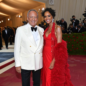 Chef Wolfgang Puck and Gelila Assefa at the Met Gala. Both dressed in extravagant evening wear. Red carpet ambiance.