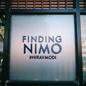 Digital illustration featuring 'Finding Nimo' logo in sleek, modern font on a vibrant red backdrop. Below the logo, the hashtag #Niravmodi is prominently displayed.