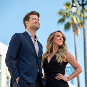 Nick Zano and Haylie Duff attending the Hollywood Walk of Fame unveiling ceremony. Dressed in formal attire, they stand confidently against a bright blue sky backdrop with palm trees