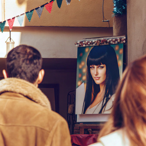 Nico Robin's wanted poster. Vibrant colors, a bustling market scene backdrop. Festive decorations hang above. Her face stands out, bold and striking amidst the chaos.