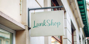 A sign on the old otantic street says "LunkShop". Keep the writing style simple, and cool. The colors are soft.