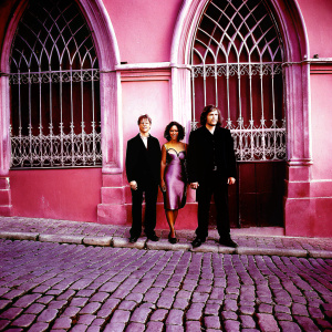 Benjamin McKenzie, Jada Pinkett Smith, and Donal Logue at a Hollywood premiere. Gothic-style building backdrop with intricate ironwork and cobblestone street visible.