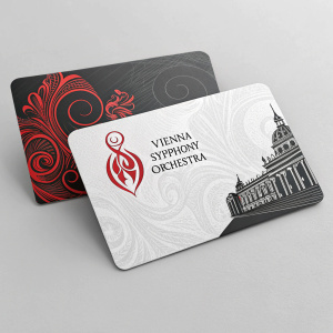 Close-up shot of business cards for the Vienna Symphony Orchestra. Black and white design with red accents on a gray background.