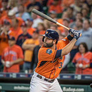 Alex Avila, Detroit Tigers player, intensely focused in batting stance. Cheering fans in vibrant jerseys fill the stadium background.