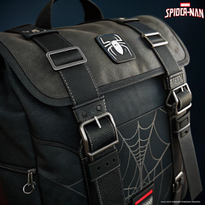 Close-up of Spider-Man's bag, black fabric with straps and buckles. Marvel logo prominent. Digital photo, dark background.
