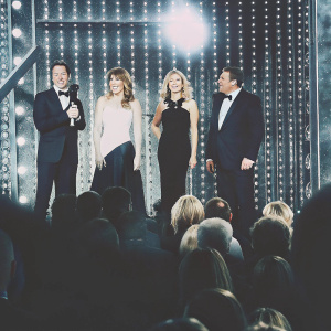 Ben Shephard, Kate Garraway, Charlotte Hawkins, and Richard Arnold on the vibrant stage of the Golden Globe Awards. They are all dressed in formal attire, striking poses against a backdrop of flashing lights and enthusiastic crowd.
