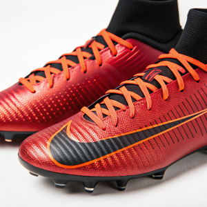 Red and black Nike Mercurial Superfly soccer cleats. Shiny surface, orange laces. Detailed pattern and logo